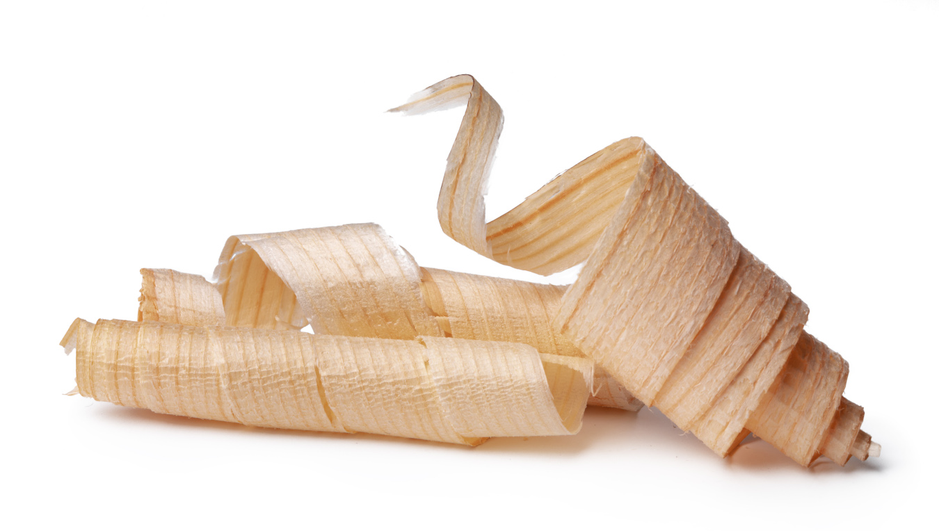 Menuiserie à Jodoigne : gros plan sur des copeaux de bois issus de la fabrication artisanale de meubles et escaliers.